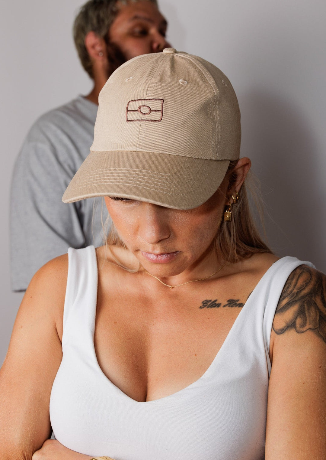Clothing The Gaps. The OG 2.0 Cap. Beige adjustable cap. With embroidered brown outline of aboriginal flag on front. 'Wear your values' text embroidered on side of cap in same brown colour. Clothing The Gaps embroidered on back in brown stitching. Adjustable clip strap on back with silver clip featuring Clothing The Gaps logo.