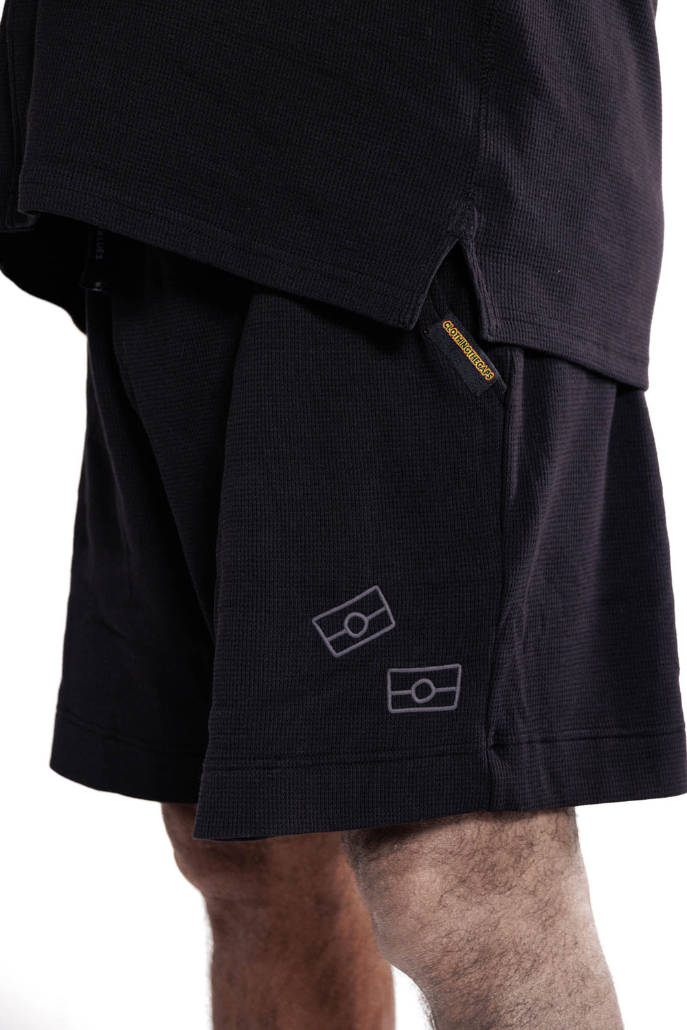 Clothing The Gaps. Waffle Shorts.  Cotton waffle material with 2 dark grey contrasting Aboriginal flag outlines on left leg of shorts. Deep pockets. 'wear your values' Draw string. Elastic waist. 