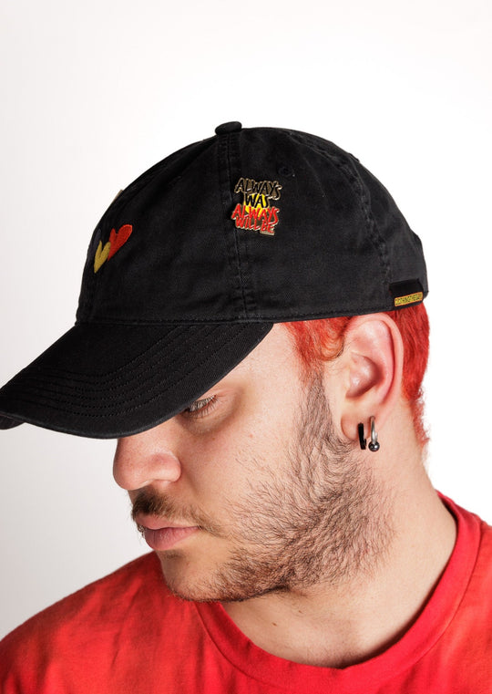 Clothing The Gaps. Pin with Black, yellow and red 'always was always will be' text outlined in gold with a gold backing.