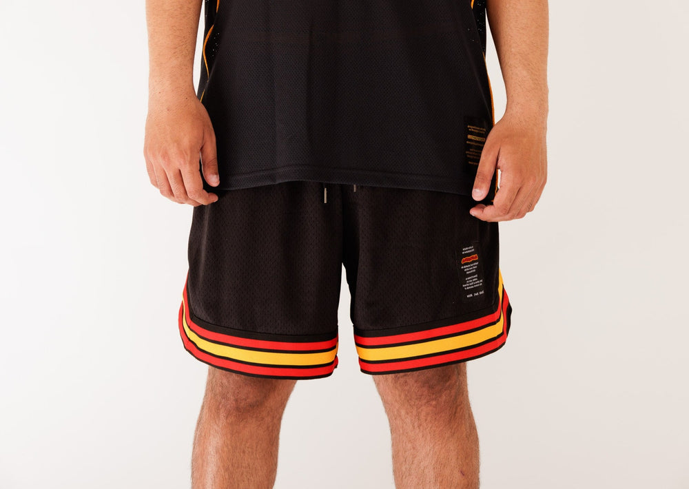 Clothing The Gaps. Blak Basketball Shorts. Retro look with red, black and yellow stripes around bottom of shorts, on pocket opening and around waist band. Rest of the shorts are a black mesh material. Has a elastic waist, black drawstrings, deep pockets and clothing the gaps patch on corner of left leg.