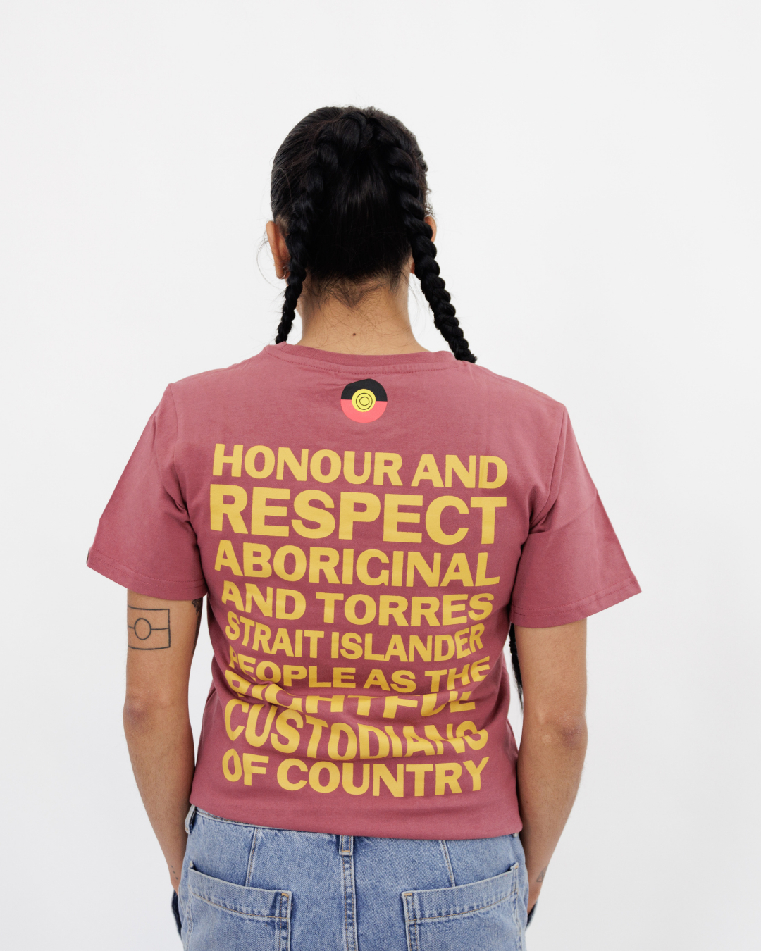Clothing The Gaps. Kids Plum Honour Country Tee. Plum pinky purple t-shirt with screen printed mustard yellow bold capital text 'Honour and respect Aboriginal and Torres Strait Islander people as the rightful custodians of country.' The word 'Honour country' on the front in the same text and contrasting colour.