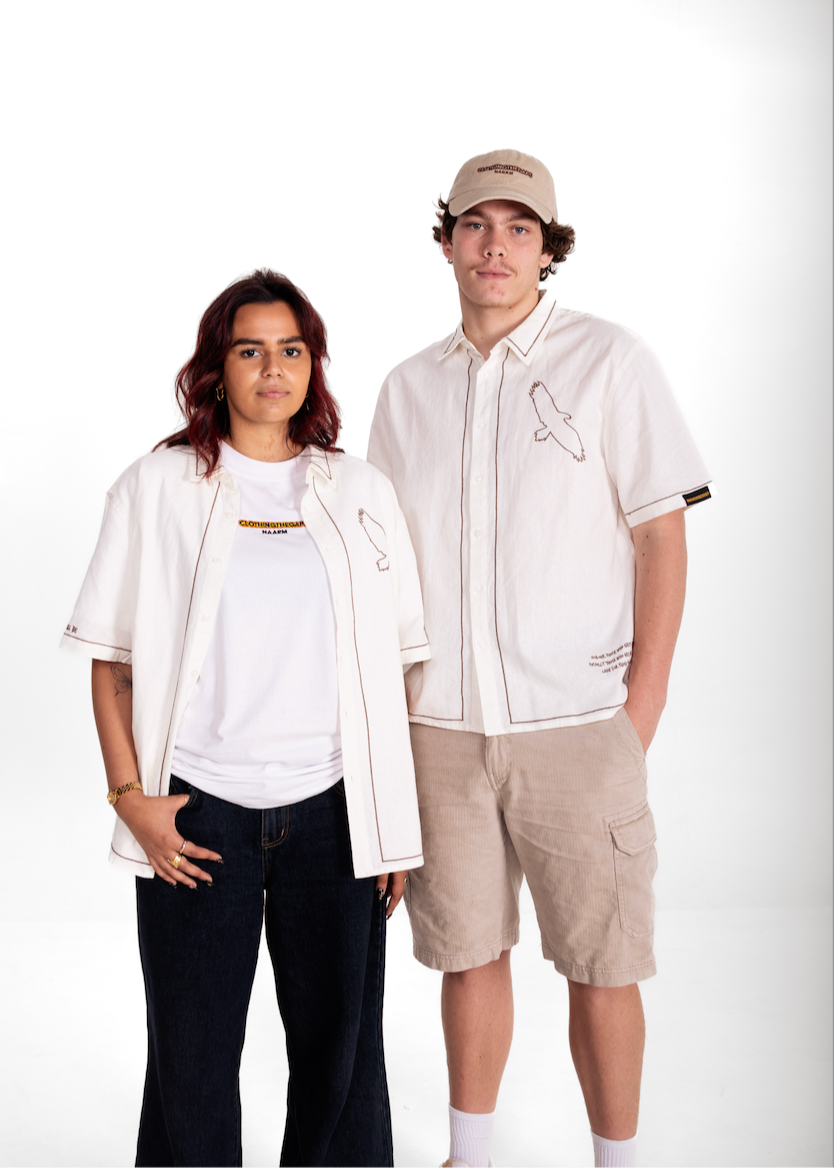 Two people wearing matching Clothing The Gaps Spirit white shirts with a logo on a white background