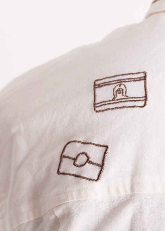 White shirt with embroidered  first nation flag designs on a white background