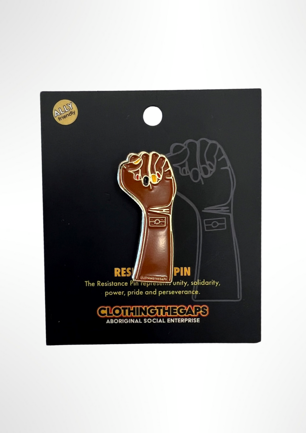 Clothing The gaps. Resistance Pin. Detailed brown resistance fist with red, black and yellow painted nails and aboriginal flag on wrist of fist. With gold outlines and backing. 