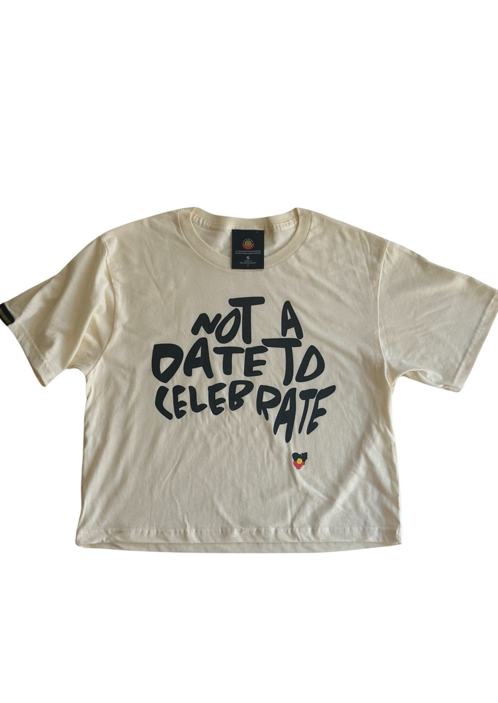 Clothing The Gaps. Not A Date To Celebrate Crop Tee. Cream cropped tee with screen printed 'Not A Date To Celebrate' black text in the shape of Australia and the Aboriginal flag in the shape of Tasmania.