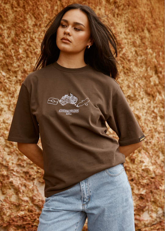 Woman wearing a Clothing The Gaps brown t-shirt with a logo against a textured brown background