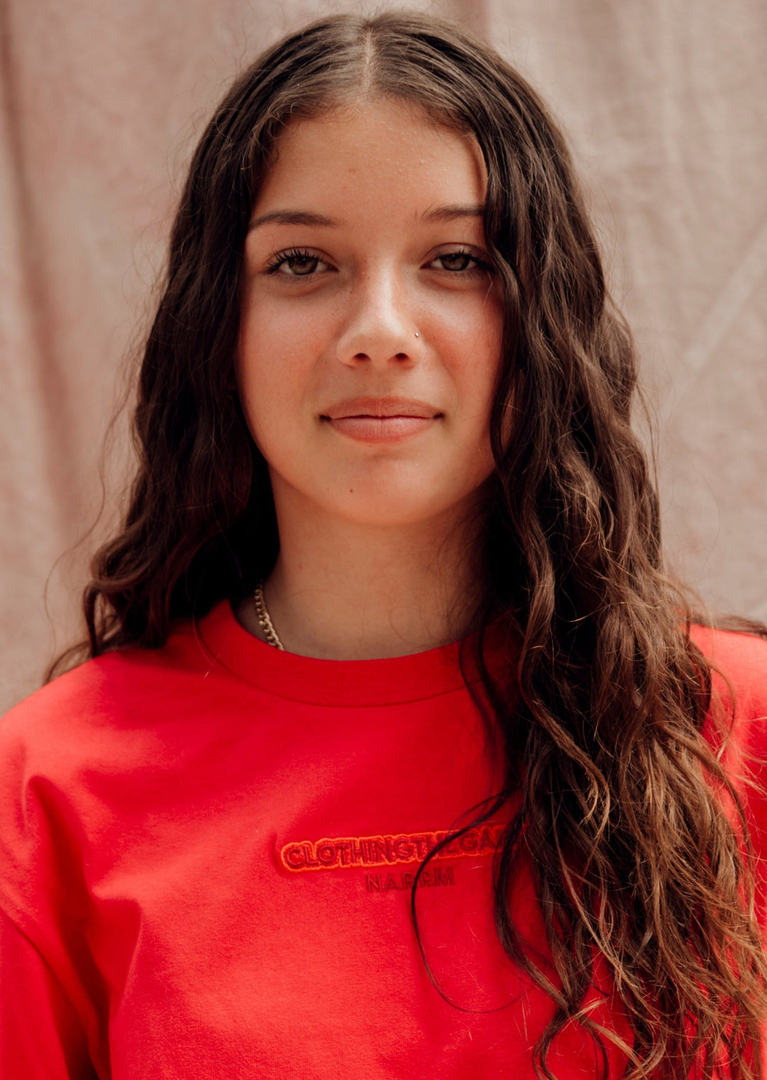 Clothing The Gaps. Land Tee. Red T-shirt. With embroidered 'Clothing The Gaps' on front chest with minimalist font in a contrasting light red colour and 'Narrm' in a dark red embroidered underneath, acknowledging the land on which Clothing The Gaps operates it's social enterprise.