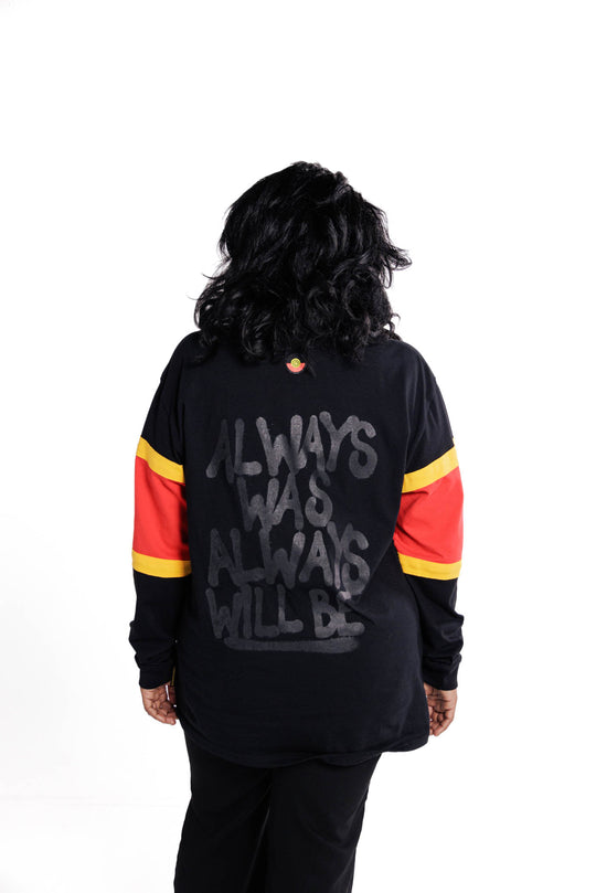 Clothing The Gaps. Black Power Longsleeve. Red, black and yellow sleeves. Aboriginal flag outline embroidered in black on the front. On the back of the hoodie a screen printed powerful Aboriginal chant 'Always Was, Always Will Be' looks like it has been sprayed on with a black spray can! The Clothing the Gaps circle logo patch of red, black and yellow just below neckline centred on upper back.