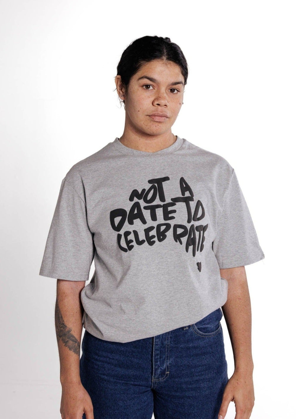 Clothing The Gaps. Not A Date To Celebrate Tee. Grey tee with screen printed 'Not A Date To Celebrate' black text in the shape of Australia big on the front chest of t-shirt.