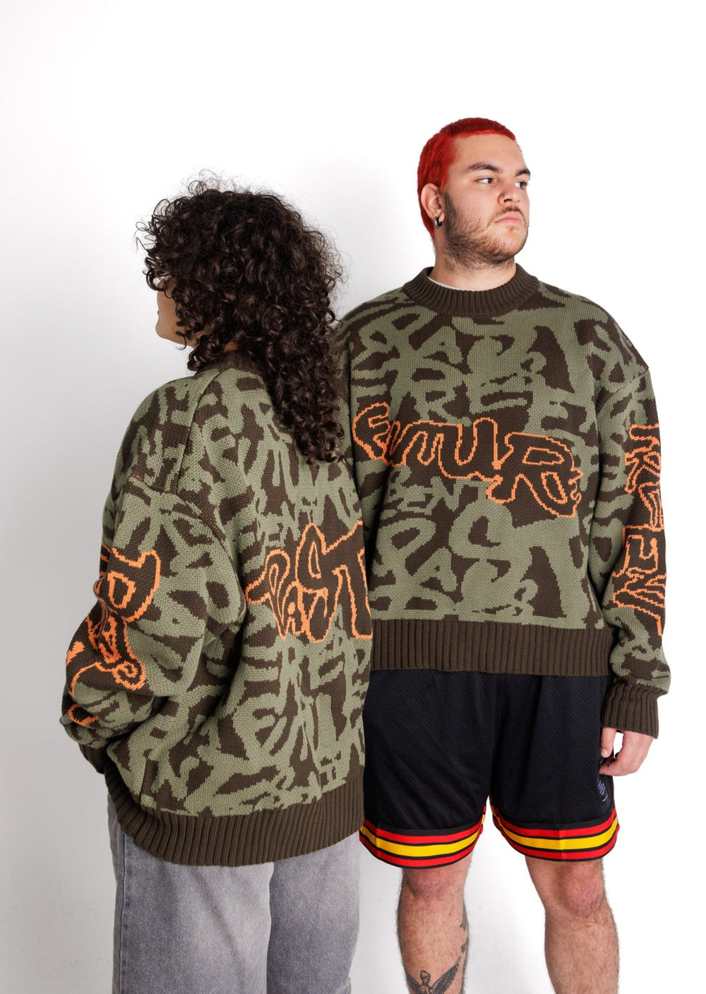 Clothing The Gaps. Past Present Future Knit Jumper. Khaki green colorway heavyweight 100% cotton oversized boxy fit. Has the words 'Past Present Future', in a kahki green graffiti background and 'future' on the front, 'past' on the back, and 'present' running down the arm in a orange outline. The background pattern seamlessly weaves the words past, present, and future. With khaki knitted cuffs and waistband.