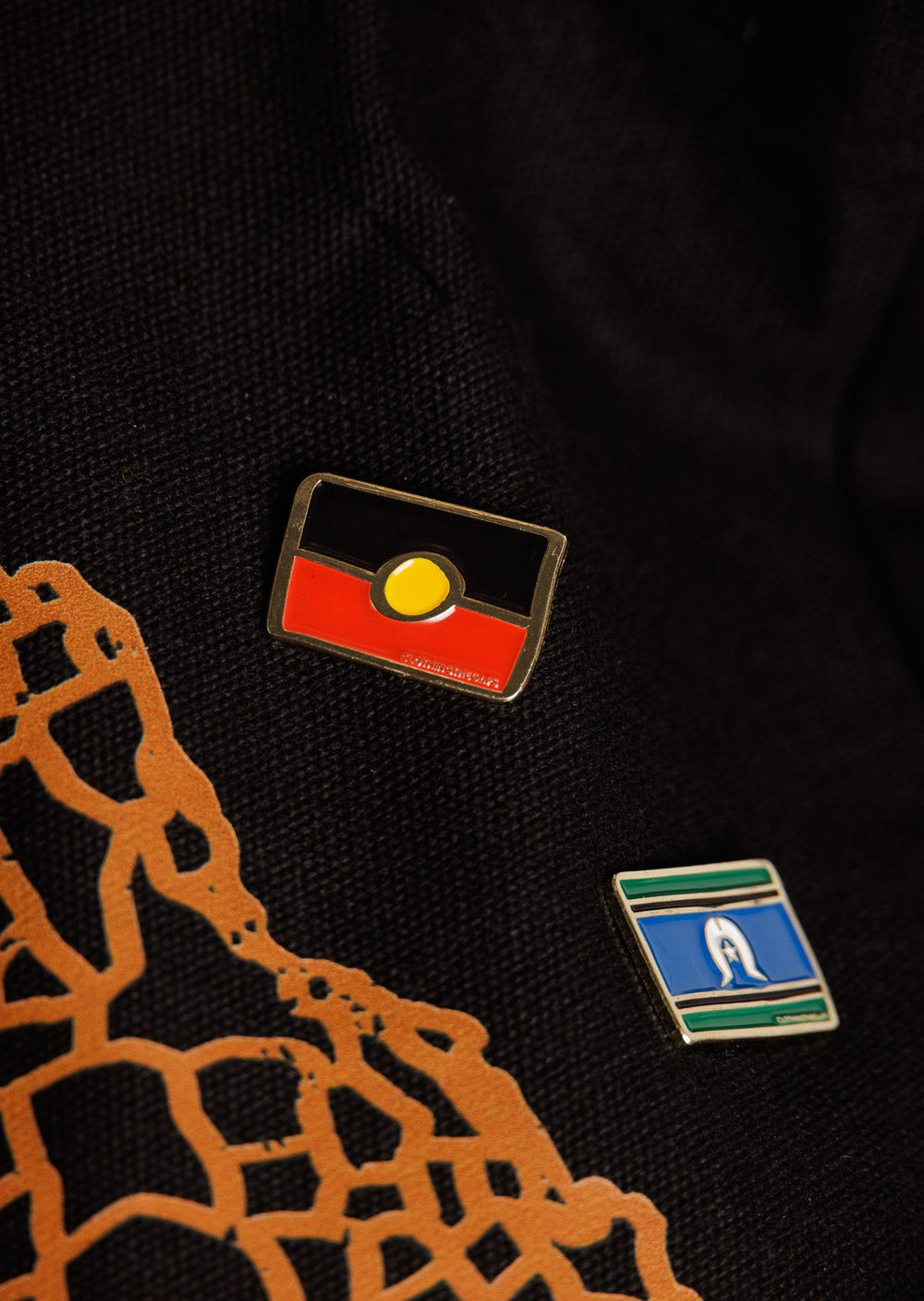 Clothing The Gaps. Black, yellow and red Aboriginal flag pin with gold outline and gold backing.