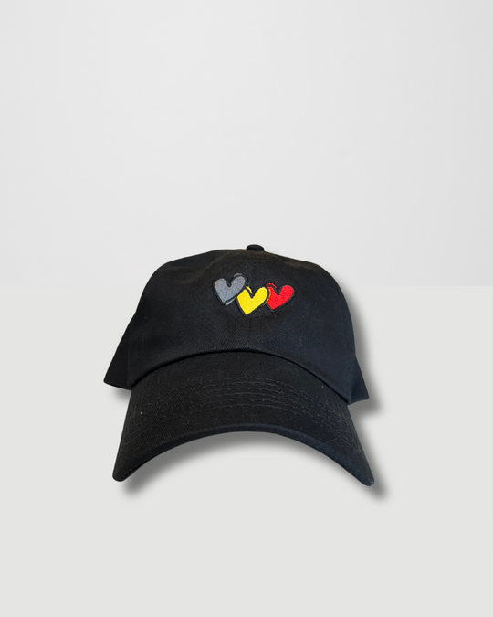 Clothing The Gaps. Blak Luv Cap. All black with  Red, black and yellow hearts embroidered on front. Clothing The Gaps embroidered on back in black stitching. Adjustable clip strap on back with silver clip featuring Clothing The Gaps logo.