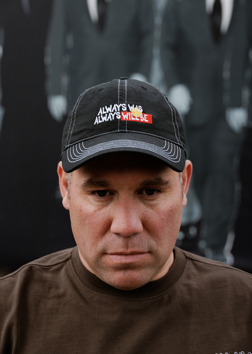Black cap with white contrast stitching and bold front embroidery shaped like the Aboriginal Flag reading Always Was Always Will Be