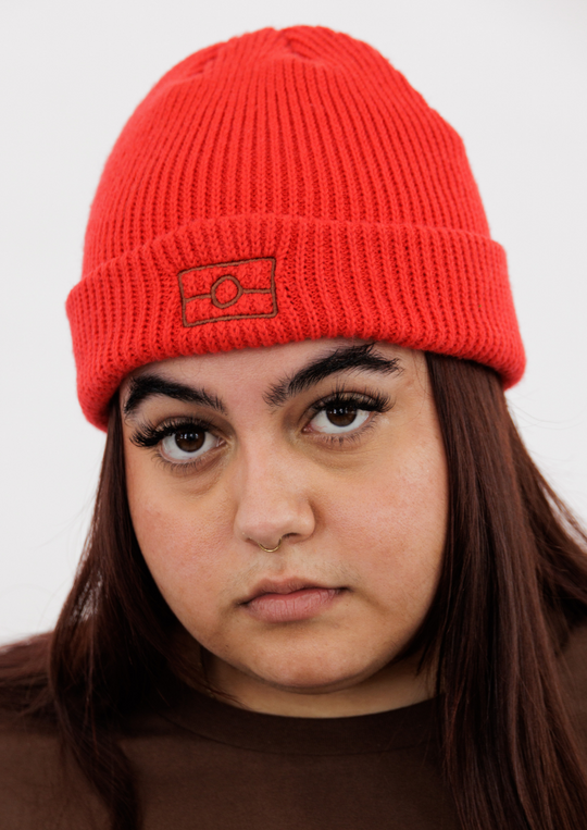 Clothing The Gaps. Narrm Flag Beanie. Available in 3 colours. Brown beanie with embroidered contrasting brown Aboriginal flag outline on fold. Red beanie with embroidered brown Aboriginal flag outline on fold. Black beanie with embroidered white Aboriginal flag outline on fold. 