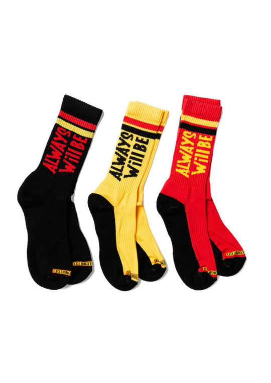 Clothing The Gaps. Power Socks 3 pack. 3 pack red, black and yellow thick cotton socks. Pair 1 Black base sock with 'Always was' on one side of sock and 'Always will be' on other side with red capital text and red and yellow band near top of sock. Pair 2 Red base sock with same text but in yellow and black. With yellow band near top of sock. Pair 3 yellow base sock with same text but in black. With black and red band near top of sock.