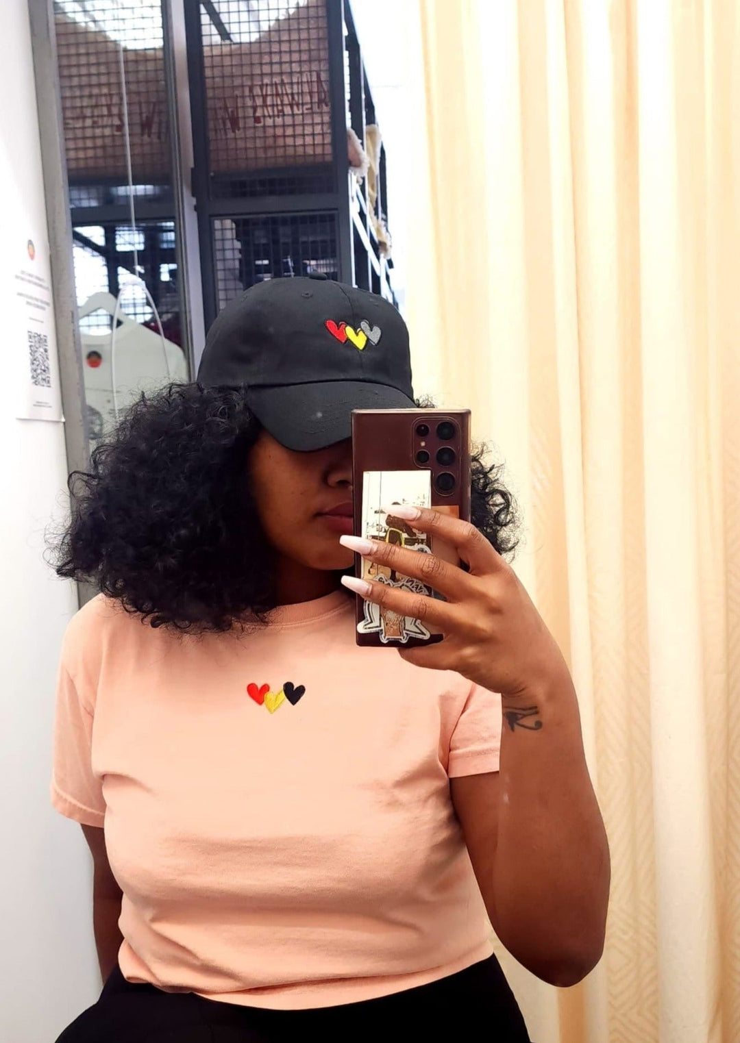 Clothing The Gaps.Peachy Blak Luv Crop Tee. peachy pink cropped tee with  Red, black and yellow hearts embroiled on front the colours of the aboriginal flag.
