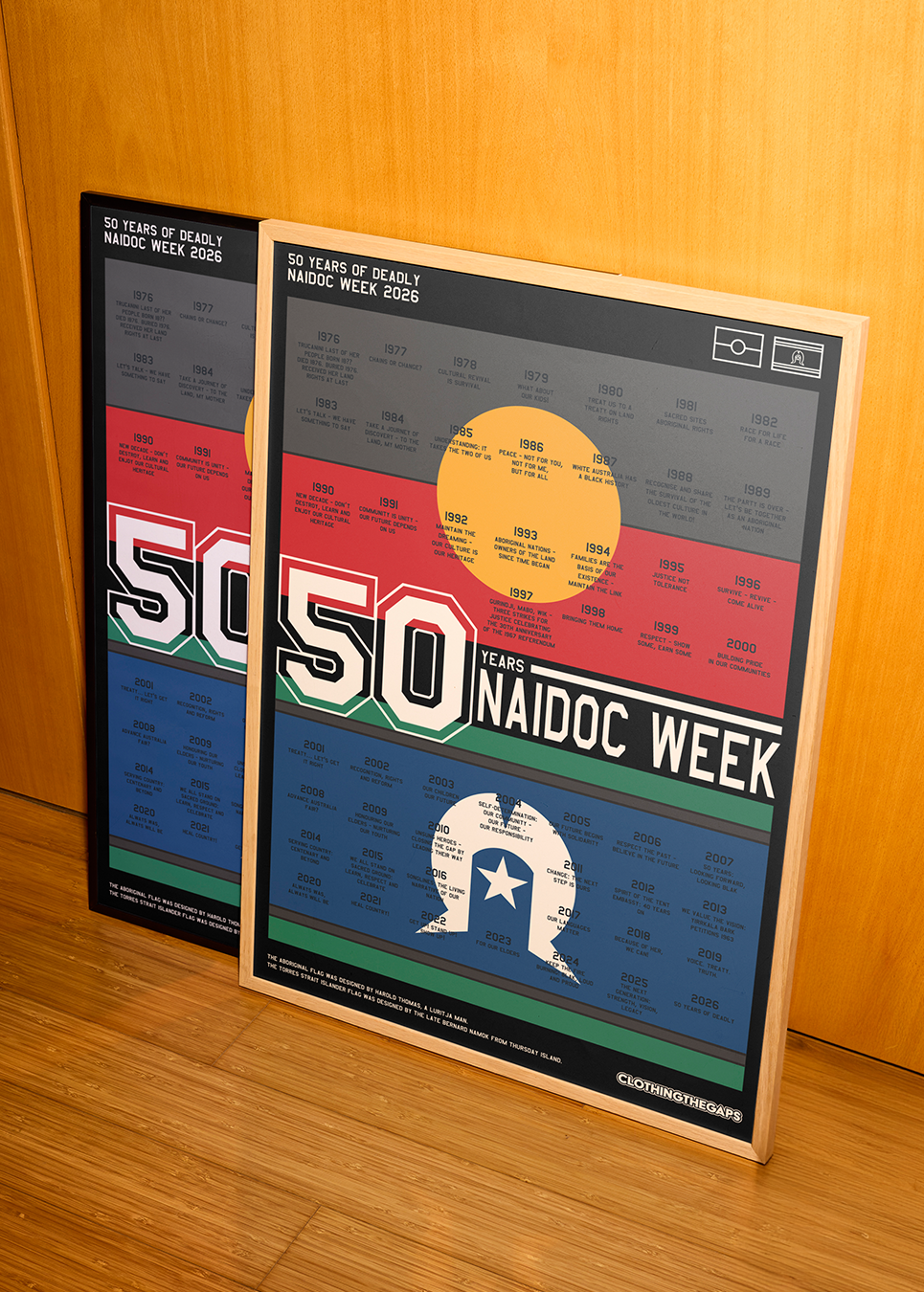 Framed posters celebrating 50 years of NAIDOC Week on a wooden floor. Clothing The Gaps NAIDOC Poster 2026