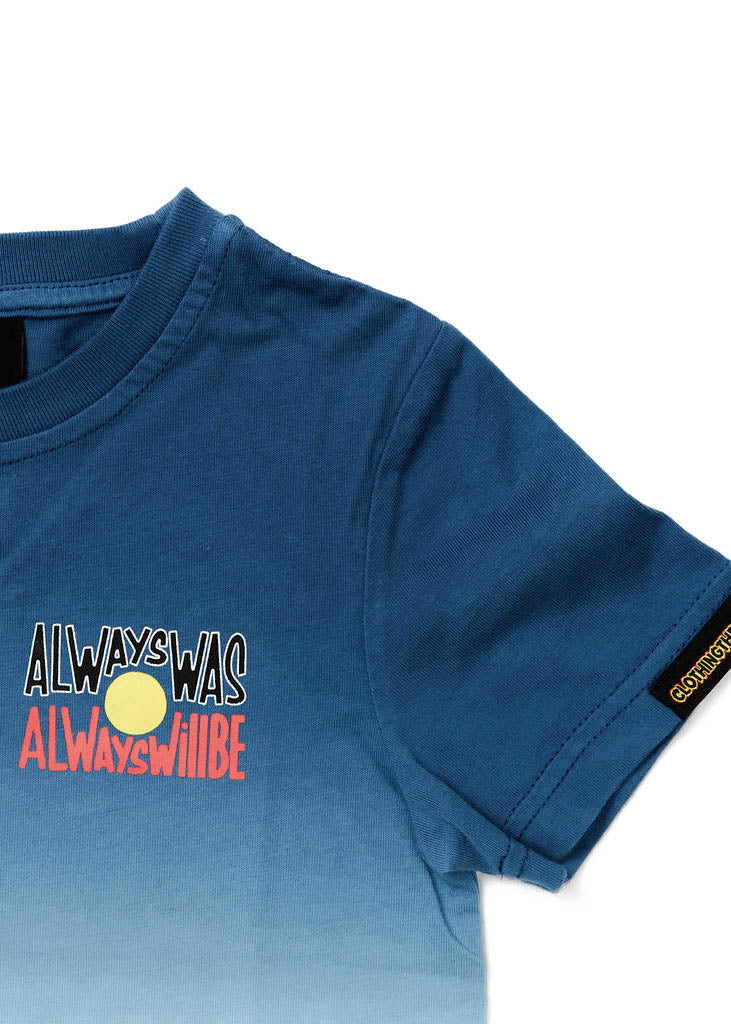 Clothing The Gaps. Kids Dip Dye 'Always Was, Always Will Be' Tee. Blue died t-shirt that fades down from the top of t-shirt to lighter blues then a cream white. With a Black, yellow and red 'always was always will be' text screen printed in left corner pocket sized.