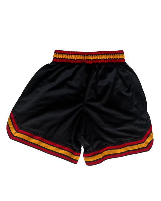 Clothing The Gaps. Blak Basketball Shorts. Retro look with red, black and yellow stripes around bottom of shorts, on pocket opening and around waist band. Rest of the shorts are a black mesh material. Has a elastic waist, black drawstrings, deep pockets and clothing the gaps patch on corner of left leg.