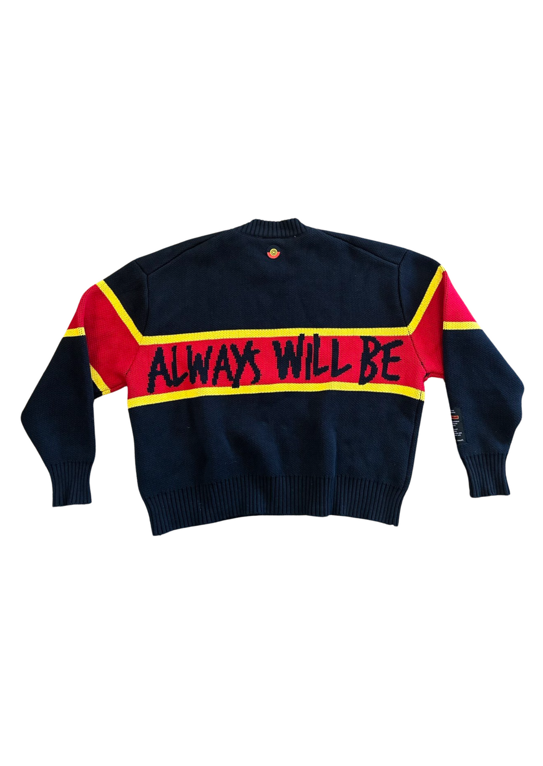 Clothing The Gaps. Power Knit Jumper. Red, black and yellow colorway heavyweight 100% cotton oversized boxy fit. Black base with thick yellow top and bottom lines and red fill in mid section of jumper that flows into same pattern on sleeves. In red section on front of jumper in bold hand-written type capital text reads 'Always was' and on back in same text 'Always will be.' With black knitted cuffs and waistband.