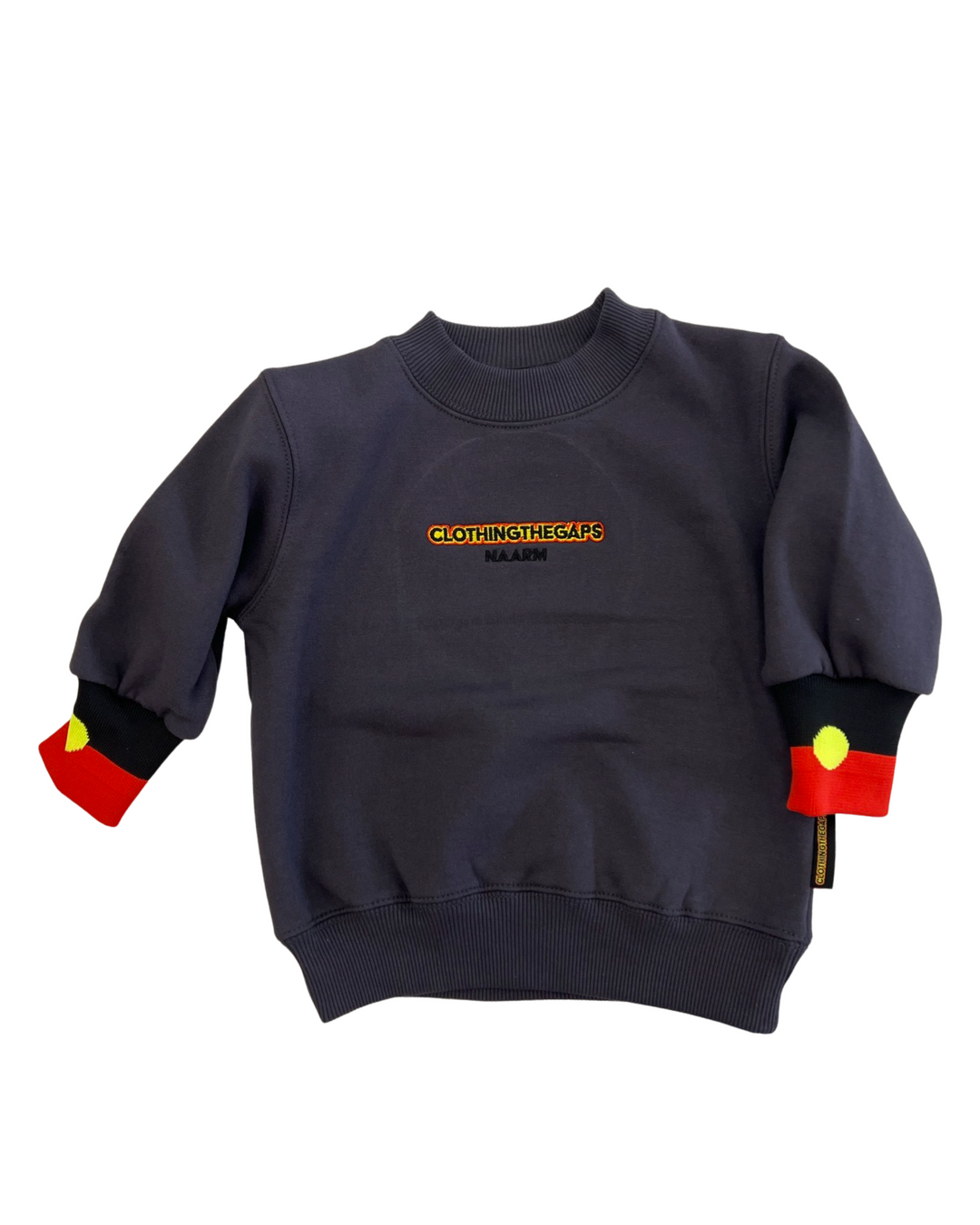 Clothing The Gaps. Kids Charcoal Crew Jumper. Charcoal dark grey crew neck jumper. With black, yellow and red 'Clothing the gaps' and the word 'Narrm' embroidered on the front of crewneck.' The wrist cuffs of the crew have a woven aboriginal flag on them. 