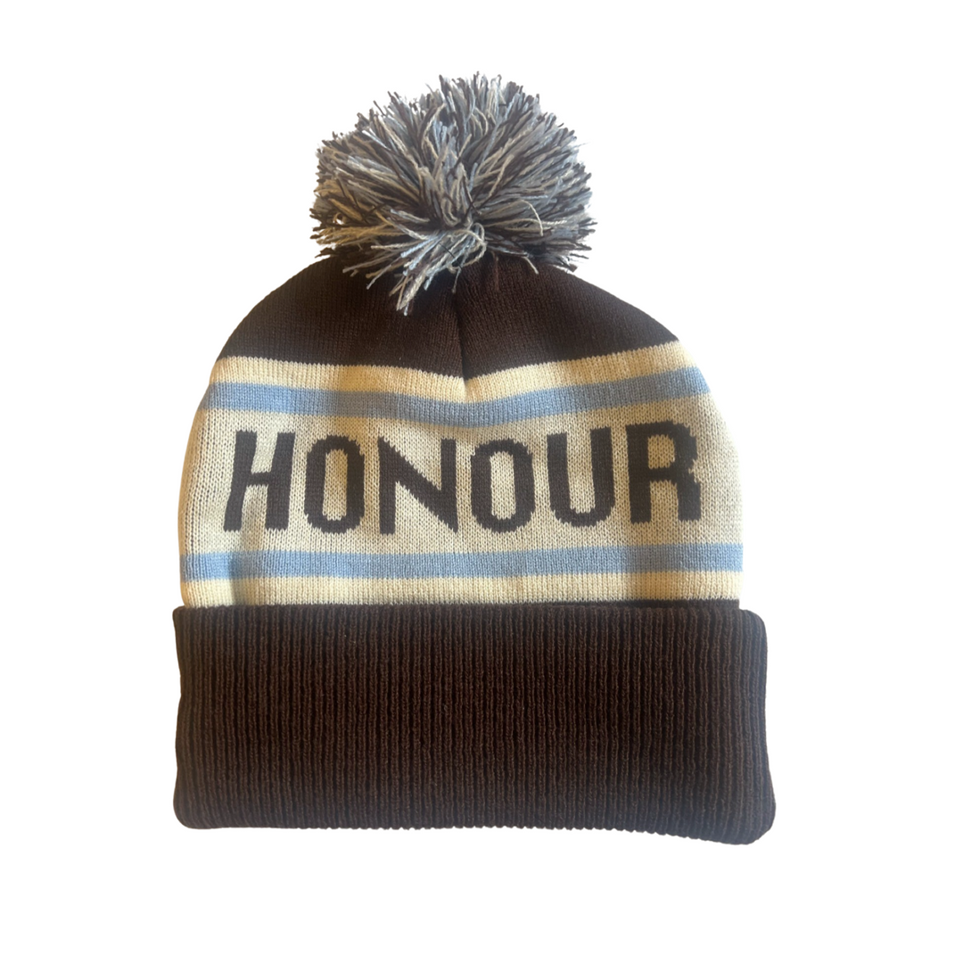 Clothing The Gaps. Honour Country Beanie. Chocolate brown base with thick butter cream middle section and two skinny ice blue lines above and below the chocolate brown text 'Honour Country.' Chocolate brown, butter cream and ice blue pom pom on top of beanie.