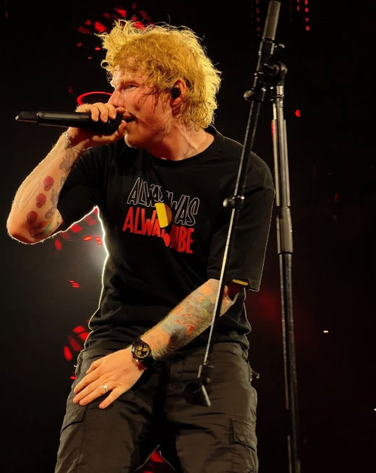 Ed Sheeran wearing. Clothing The Gaps. Black T-shirt with Black, yellow and red 'always was always will be' text screen printed in centre. Aboriginal Flag tee