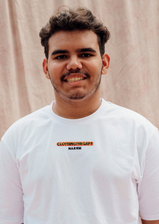 Clothing The Gaps. Spirit Tee. White T-shirt. With embroidered 'Clothing The Gaps' on front chest with minimalist font in black text with a yellow and red outline and 'Narrm' in black embroidered underneath, acknowledging the land on which Clothing The Gaps operates it's social enterprise.