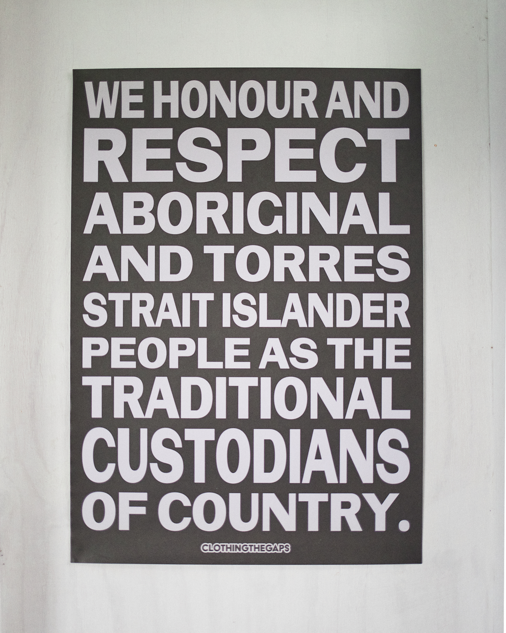 Clothing The Gaps. Honour Country Posters. Poster text 'Honour and respect Aboriginal and Torres Strait Islander people as the rightful custodians of country.' Available in Black/ White black background poster with white bold capital text and Pink/Red pink background background poster with red bold capital text.