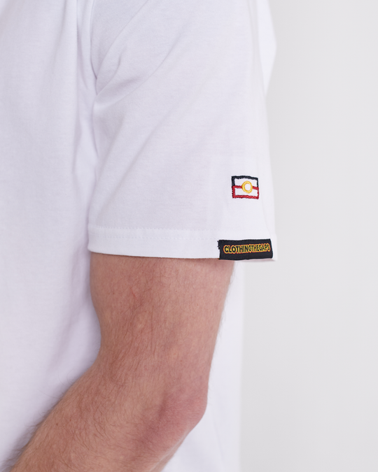 Clothing The Gaps. Spirit Tee. White T-shirt. With embroidered 'Clothing The Gaps' on front chest with minimalist font in black text with a yellow and red outline and 'Narrm' in black embroidered underneath, acknowledging the land on which Clothing The Gaps operates it's social enterprise.