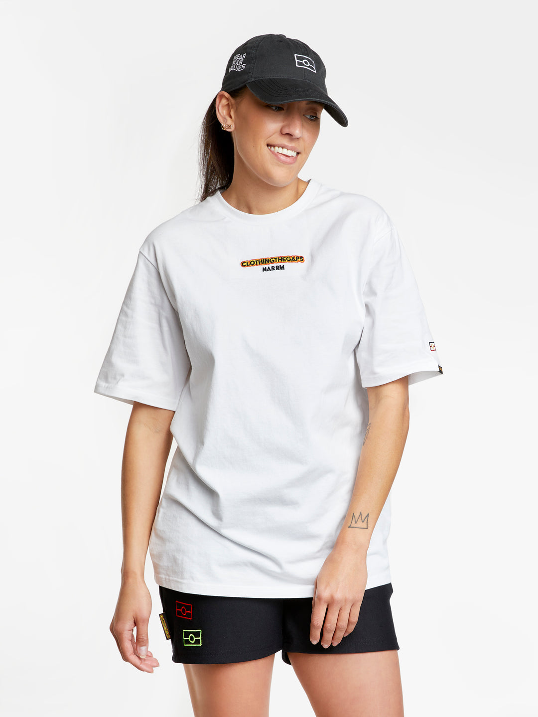 Clothing The Gaps. Wear Your Values Empty Flag Cap 2.0. Black adjustable cap. With embroidered white outline of aboriginal flag on front. 'Wear your values' text embroidered on side of cap in white. Clothing The Gaps embroidered on back in white stitching. Adjustable clip strap on back with silver clip featuring Clothing The Gaps logo.