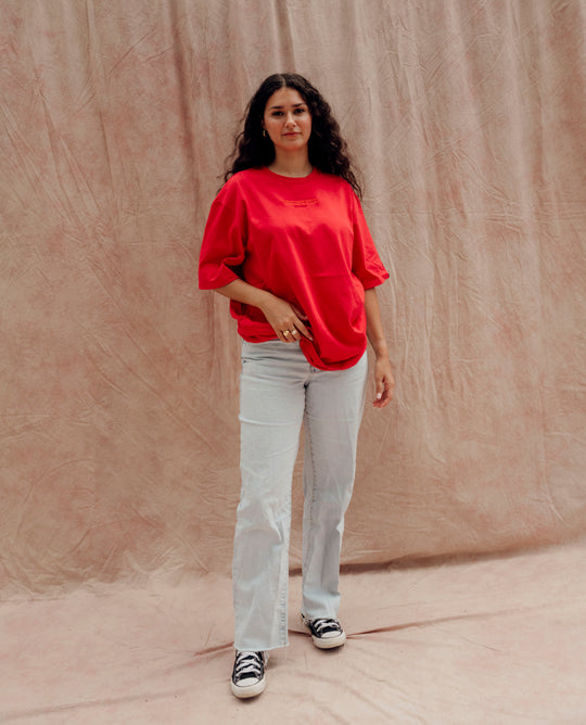 Clothing The Gaps. Land Tee. Red T-shirt. With embroidered 'Clothing The Gaps' on front chest with minimalist font in a contrasting light red colour and 'Narrm' in a dark red embroidered underneath, acknowledging the land on which Clothing The Gaps operates it's social enterprise.