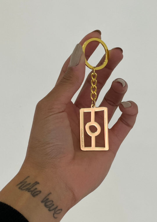 Clothing The Gaps. Flag Keyring. All gold coloured metal keyring with gold chain and loop attached to gold thick outline of Aboriginal flag. 