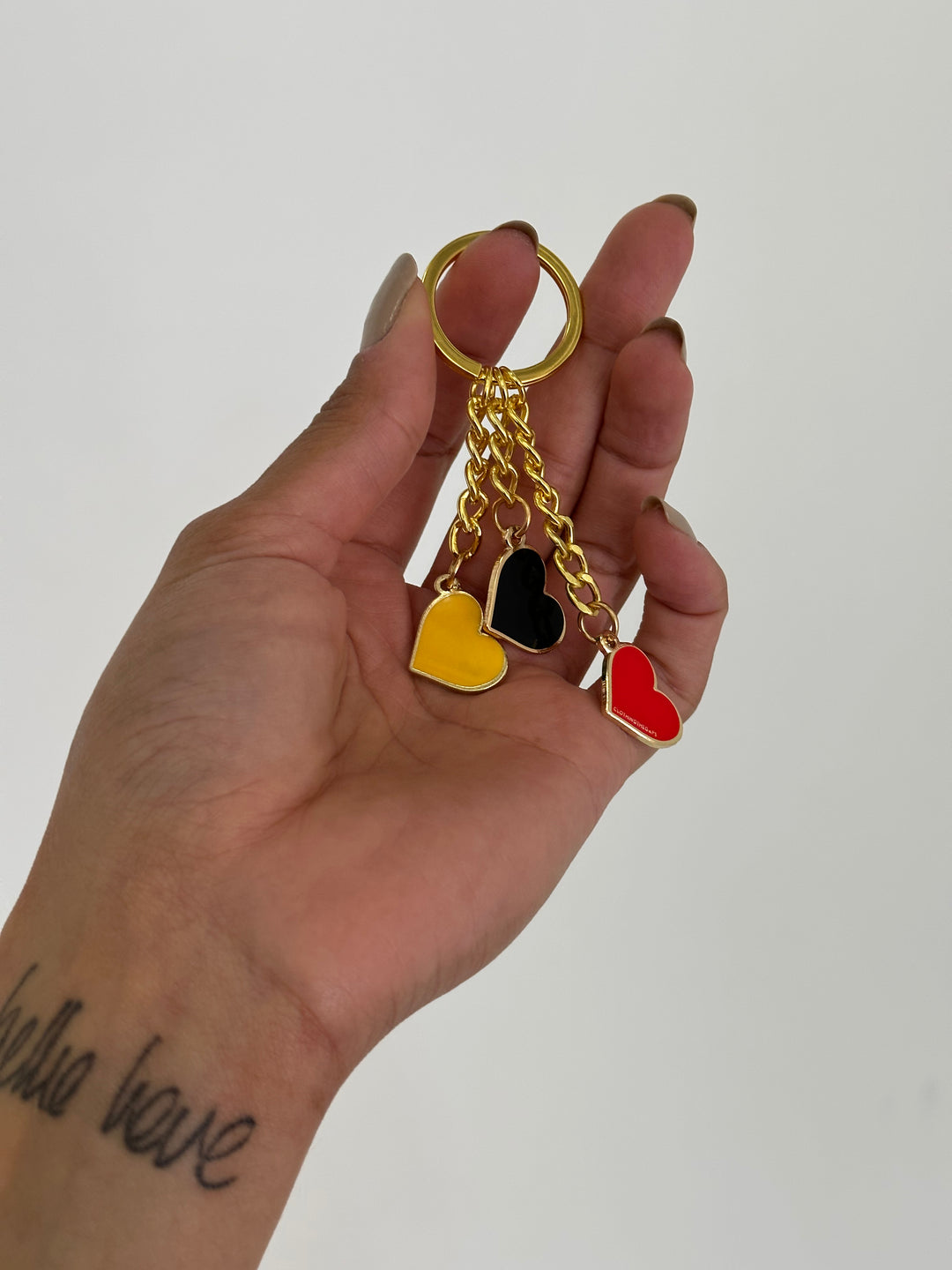 Clothing The Gaps. Blak Luv Keyring.  With gold chain and loop attached to 3 seperate hearts in the colours of the Aboriginal flag Black, yellow and red.
