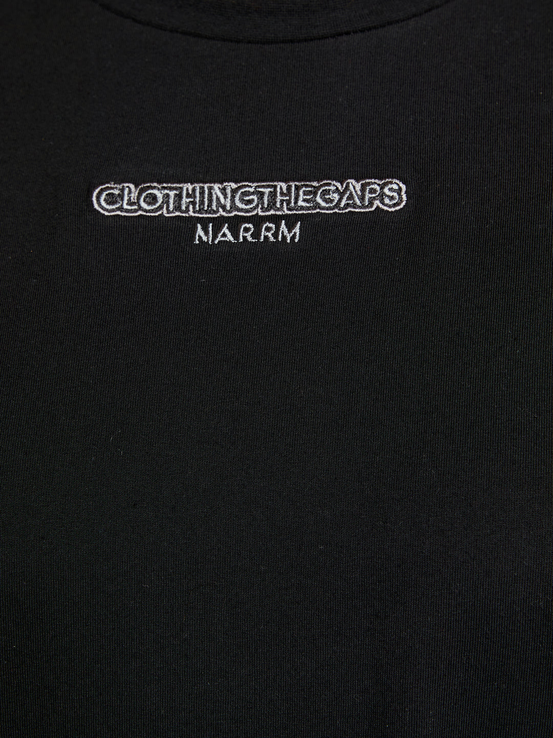 Clothing The Gaps. People Tee. Black T-shirt. With embroidered 'Clothing The Gaps' on front chest with minimalist font in a contrasting light grey colour and 'Narrm' in a light grey embroidered underneath, acknowledging the land on which Clothing The Gaps operates it's social enterprise.