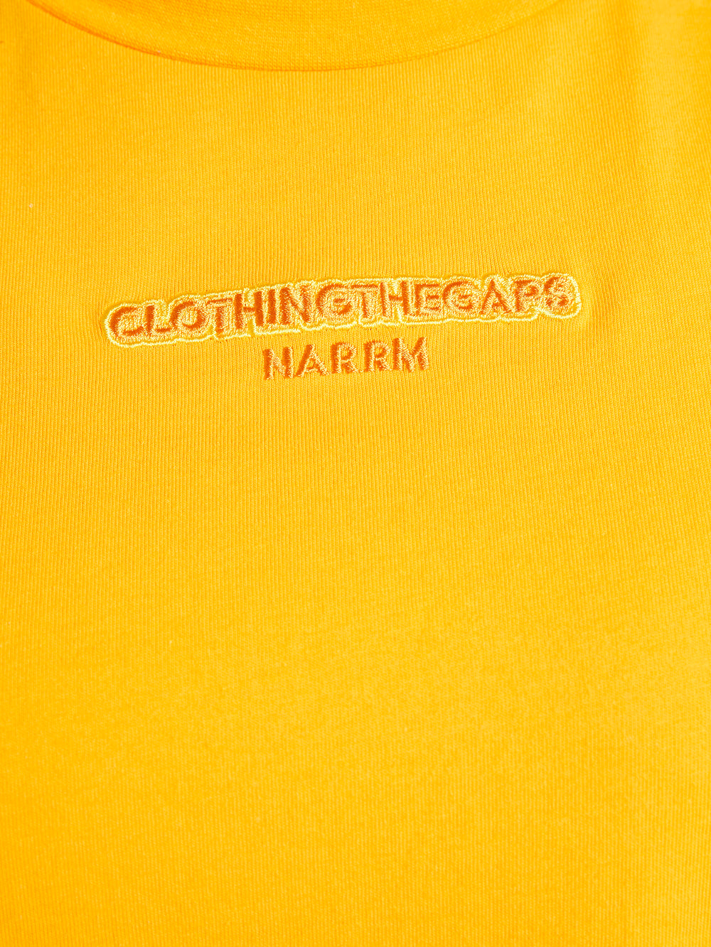 Clothing The Gaps. Sun Tee. Yellow T-shirt. With embroidered 'Clothing The Gaps' on front chest with minimalist font in a contrasting light yellow colour and 'Narrm' in a darker yellow embroidered underneath, acknowledging the land on which Clothing The Gaps operates it's social enterprise.