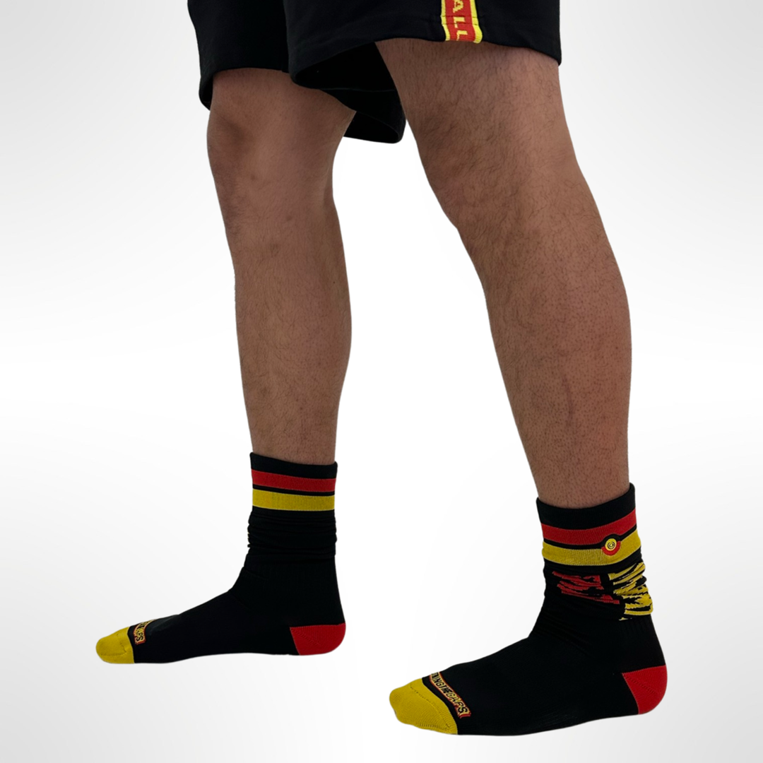 Clothing The Gaps. Team Power Socks. Long Footy knee high black footy socks. With 'Always was' on side of sock in red and 'Always will be' underneath in yellow. Red and yellow thick line near top of sock and clothing the gap logo embroidered in-betwen lines. 