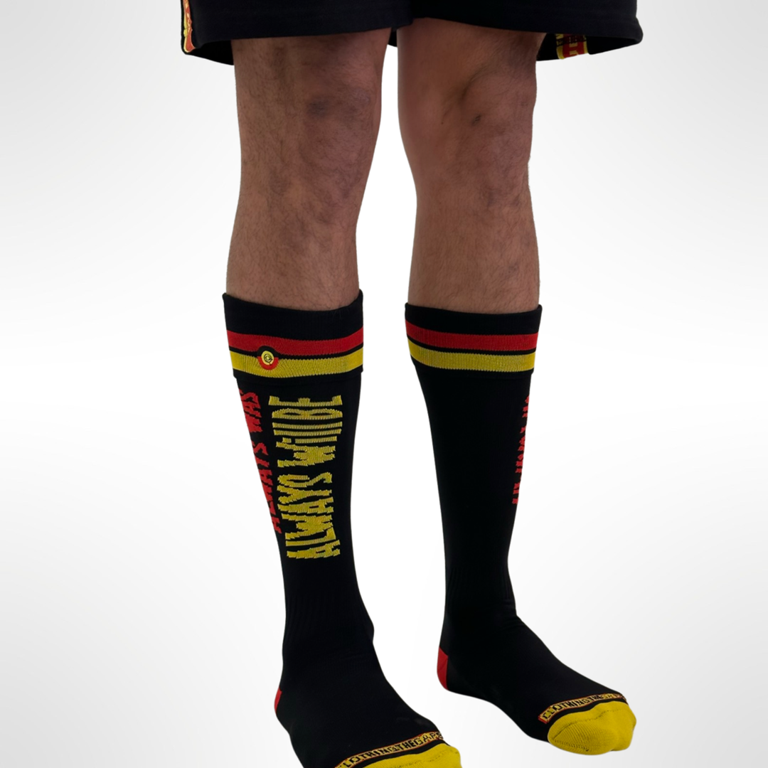 Clothing The Gaps. Team Power Socks. Long Footy knee high black footy socks. With 'Always was' on side of sock in red and 'Always will be' underneath in yellow. Red and yellow thick line near top of sock and clothing the gap logo embroidered in-betwen lines. 